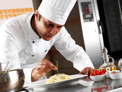 Image of chef putting finishing touch on food