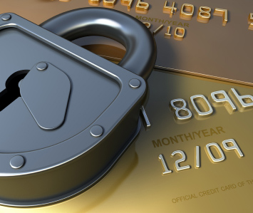 Image of a padlock laying on top of gold credit cards