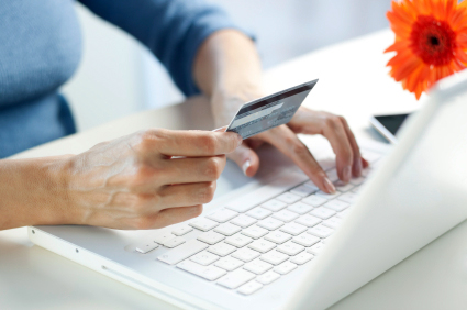 Image of person holding credit card and typing on laptop
